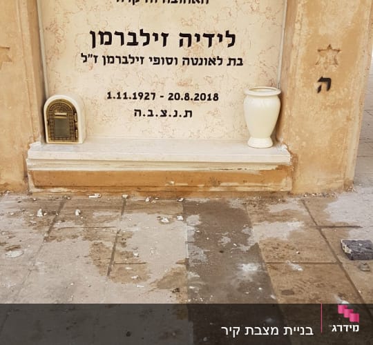 מצבה עם כיתוב בעברית ואגרטל לבן
